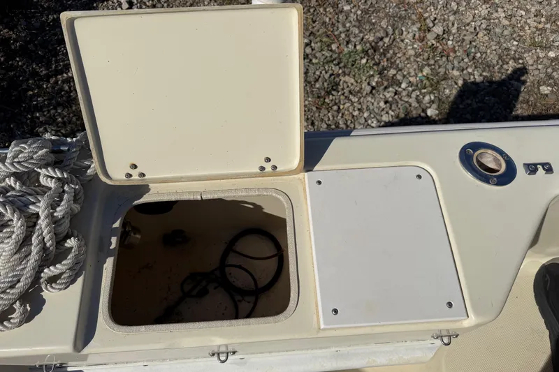 Slide: The Image of Open storage compartment on a 1995 Scout 172 Sportfish boat with coiled rope. - 17