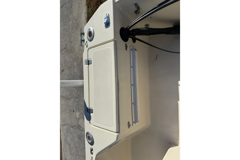 Slide: The Image of 1995 Scout 172 Sportfish boat interior, featuring storage compartment and control panel. - 18