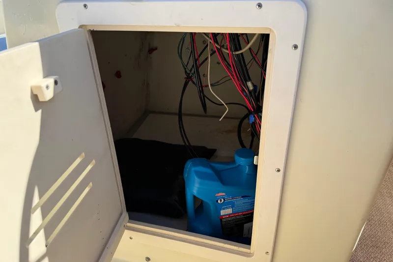 Slide: The Image of Open compartment on 1995 Scout 172 Sportfish boat showing wiring and blue container. - 27