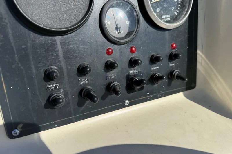 Slide: The Image of Control panel of a 1995 Scout 172 Sportfish boat with switches and gauges. - 28