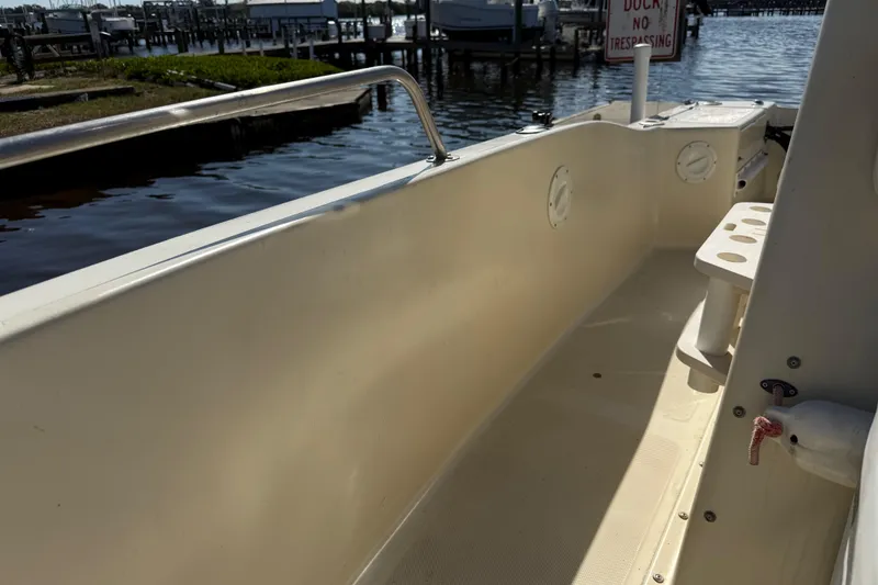 Slide: The Image of 1995 Scout 172 Sportfish boat interior by a dock, featuring seating and rod holders. - 32