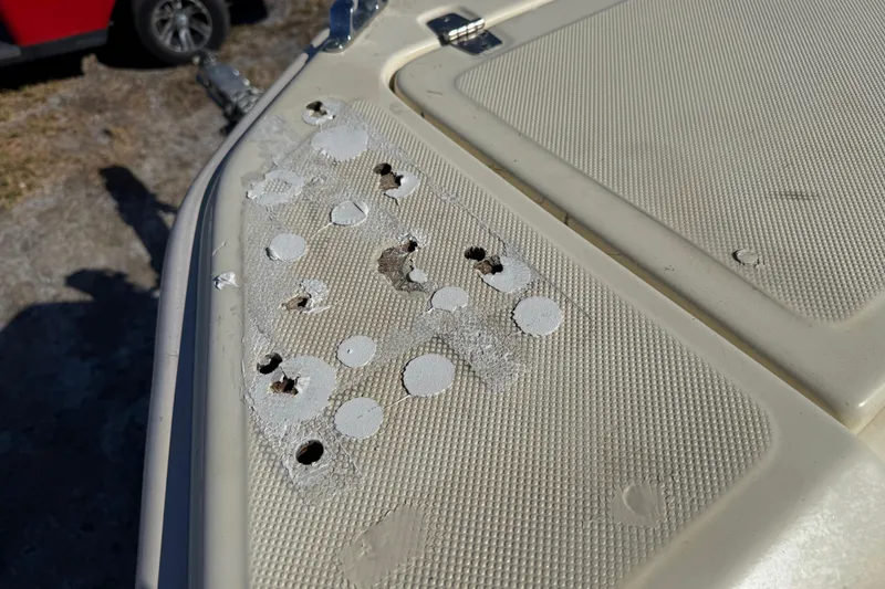Slide: The Image of Damaged deck of 1995 Scout 172 Sportfish boat with visible holes and wear. - 37