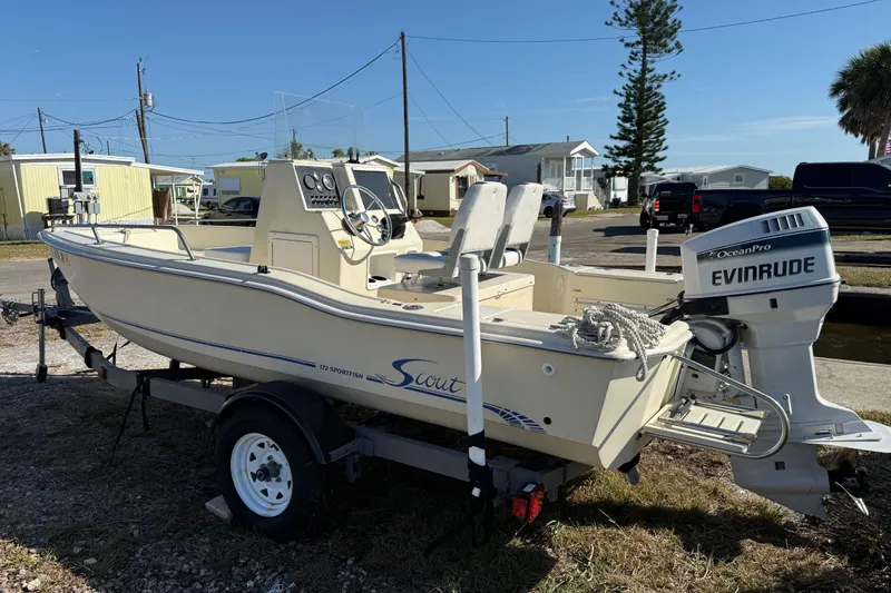 Slide: The Image of 1995 Scout 172 Sportfish boat with Evinrude motor on trailer, parked outdoors. - 4