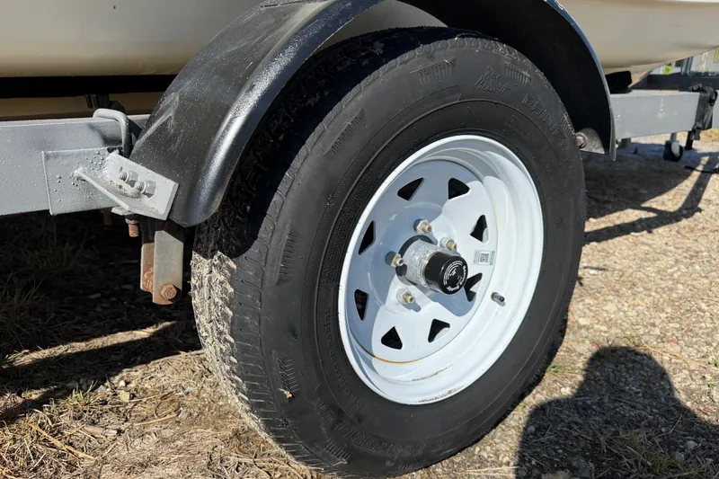 Slide: The Image of Trailer wheel of a 1995 Scout 172 Sportfish boat on gravel surface. - 9