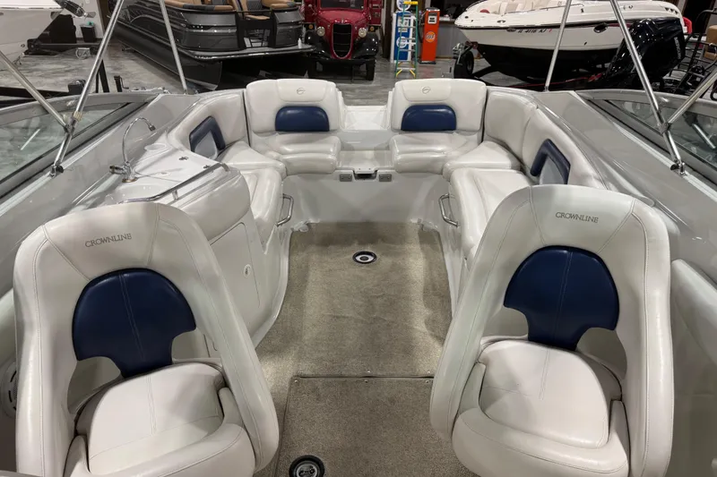 Slide: The Image of 2003 Crownline 270 BR boat interior with white and blue seating in showroom. - 10