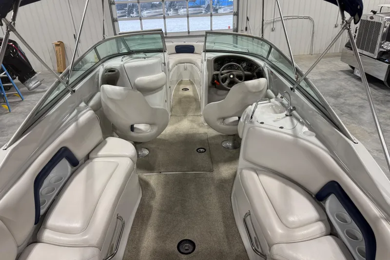 Slide: The Image of 2003 Crownline 270 BR boat interior with white seating and steering wheel. - 6