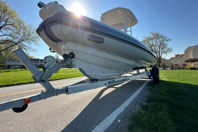 Slide: The Image of 2024 Highfield Sport 660 boat on trailer, sunlit, parked on roadside. - 10