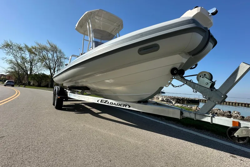 Slide: The Image of 2024 Highfield Sport 660 boat on trailer by waterfront road. - 11