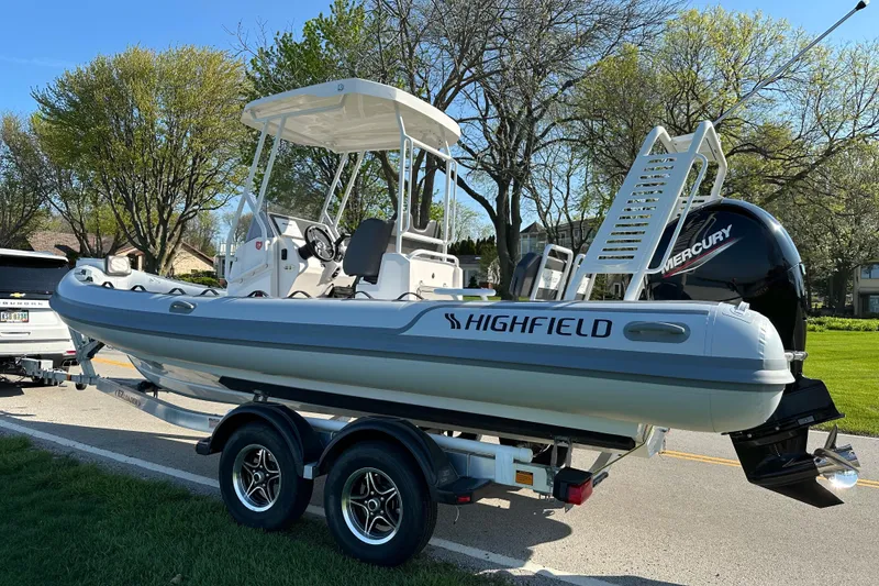 Slide: The Image of 2024 Highfield Sport 660 boat on trailer, parked on a sunny street. - 5
