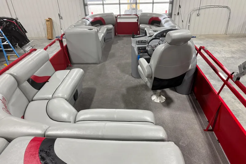 Slide: The Image of 2014 Bentley Pontoons 243 Cruise interior with gray and red seating, steering console. - 6