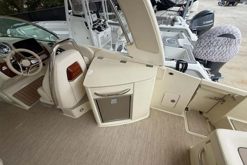 Slide: The Image of 2024 Chris-Craft Launch 28 GT boat interior with beige seating and Mercury engine. - 10