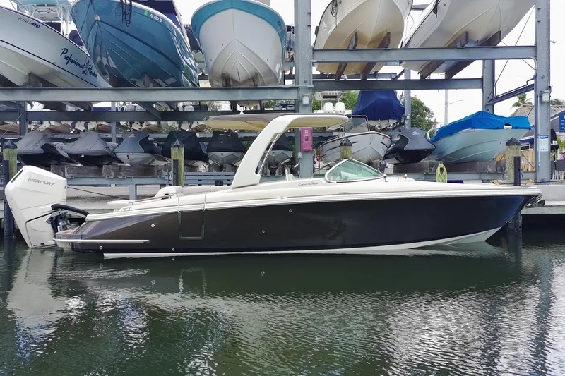Slide: The Image of 2024 Chris-Craft Launch 28 GT boat docked in marina, surrounded by other boats. - 27