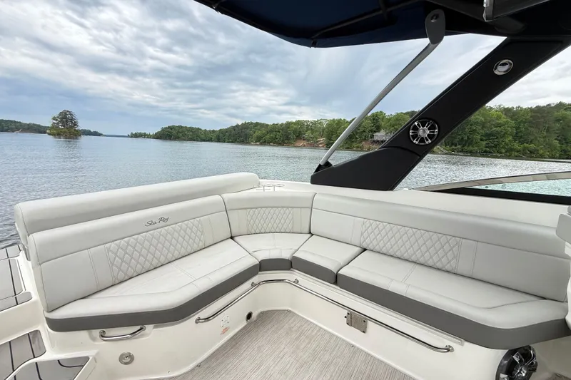 Slide: The Image of 2022 Sea Ray SLX 280 boat interior with luxurious seating, overlooking a serene lake. - 12