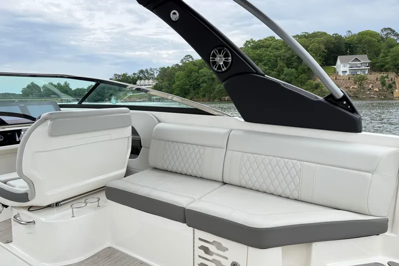 Slide: The Image of 2022 Sea Ray SLX 280 boat interior with luxurious seating and scenic lake view. - 13
