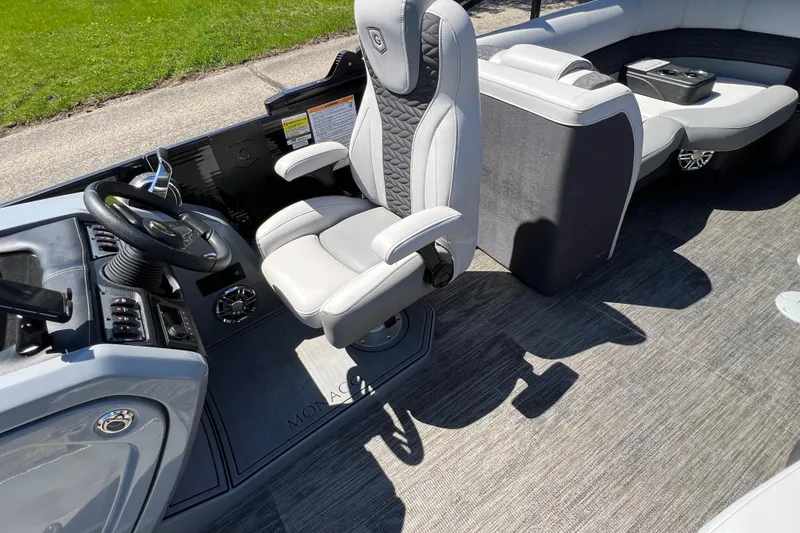 Slide: The Image of 2023 Godfrey Monaco 235 SB boat interior with captain's chair and steering console. - 24