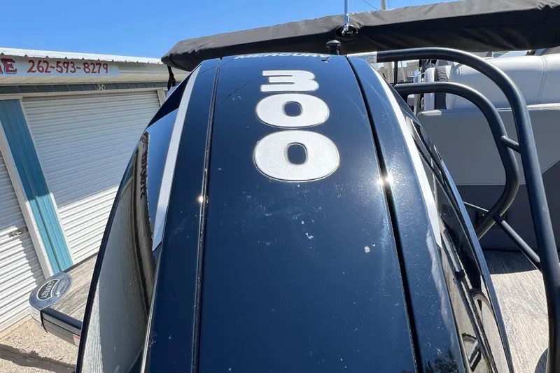 Slide: The Image of 2023 Godfrey Monaco 235 SB boat with Mercury 300 engine, parked near storage units. - 9