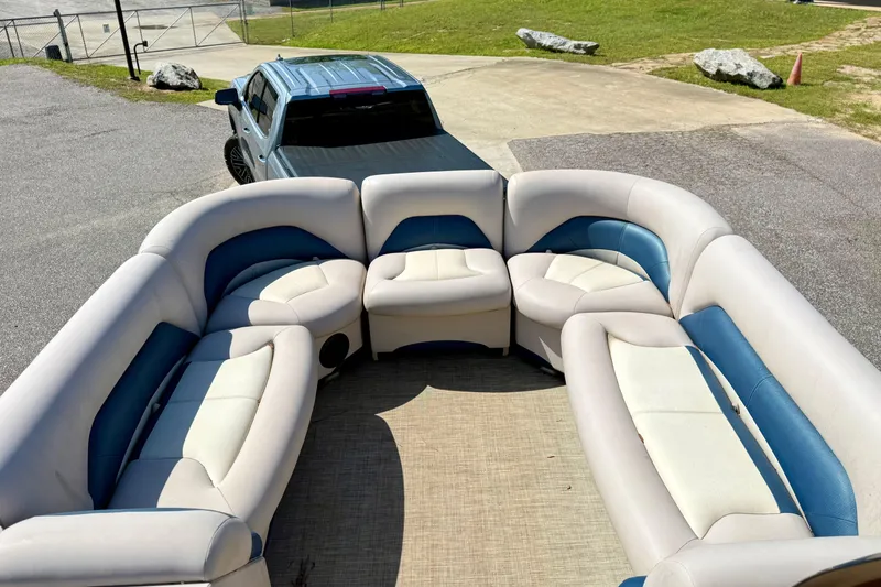 Slide: The Image of 2015 Landau Signature 2500 Cruise boat interior with plush seating, parked near a truck. - 15