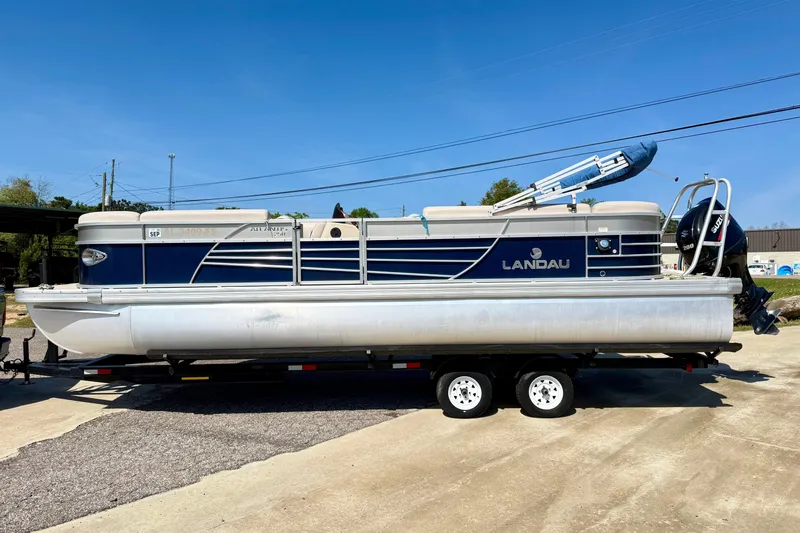 Slide: The Image of 2015 Landau Signature 2500 Cruise pontoon boat on trailer, blue and white design. - 6