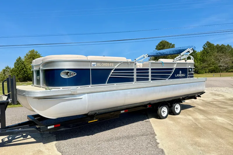 Slide: The Image of 2015 Landau Signature 2500 Cruise pontoon boat on trailer, parked outdoors. - 7