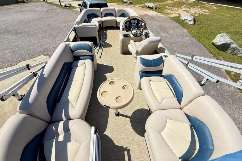 Slide: The Image of 2015 Landau Signature 2500 Cruise pontoon boat interior with plush seating and steering console. - 9