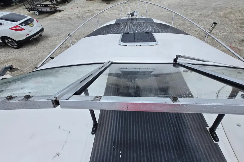 Slide: The Image of 1996 Wellcraft 26 Exel SE boat deck with open windshield, parked on gravel. - 12