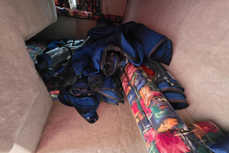 Slide: The Image of Interior of 1996 Wellcraft 26 Exel SE boat with colorful cushions and blue gear. - 16