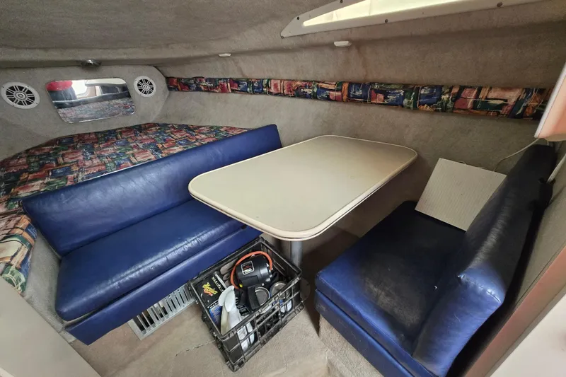 Slide: The Image of Interior of a 1996 Wellcraft 26 Exel SE boat with blue seating and a table. - 17