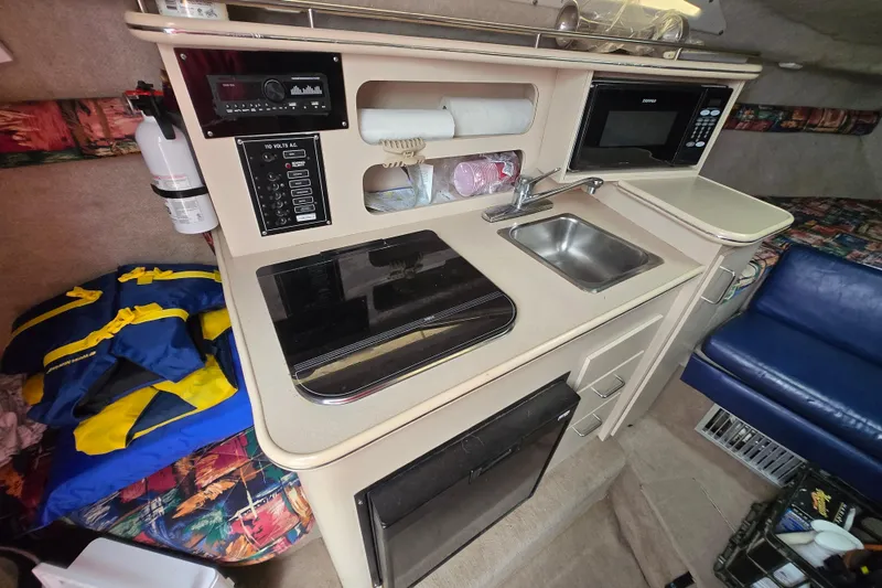 Slide: The Image of 1996 Wellcraft 26 Exel SE boat interior with kitchenette, sink, and microwave. - 18