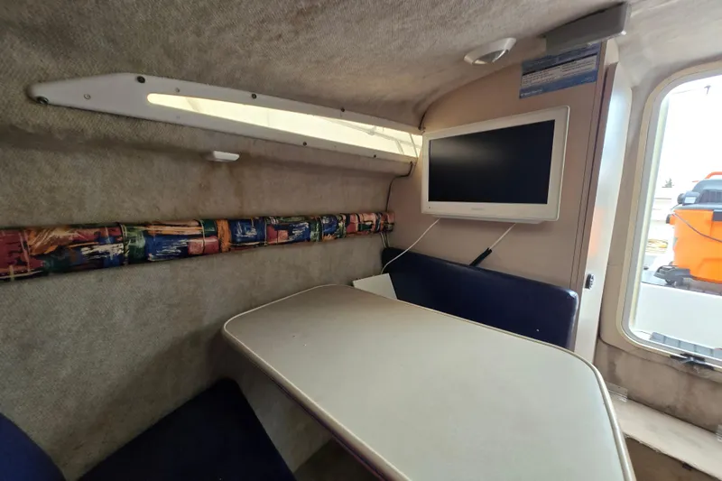 Slide: The Image of Interior of 1996 Wellcraft 26 Exel SE boat with table and mounted TV. - 25