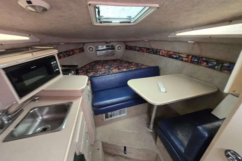 Slide: The Image of Interior of a 1996 Wellcraft 26 Exel SE boat with kitchenette and seating area. - 27