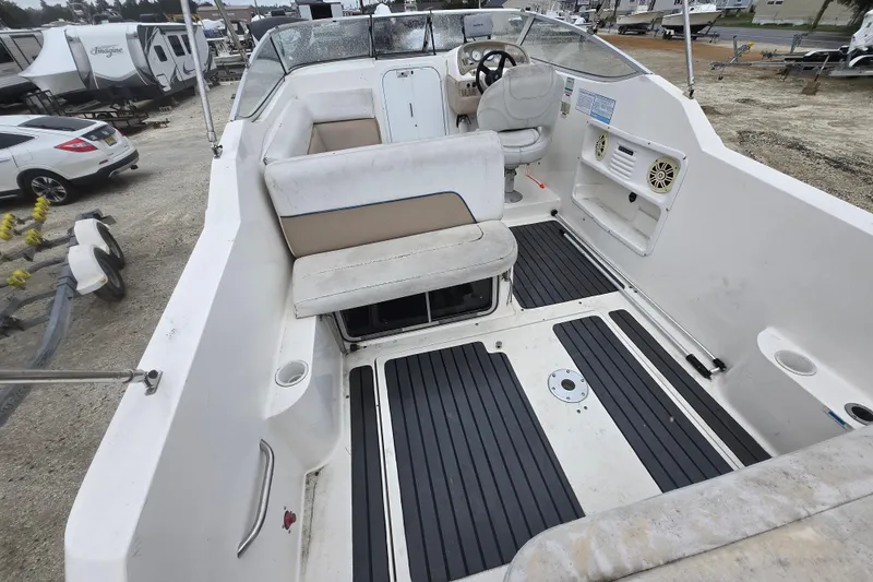 Slide: The Image of 1996 Wellcraft 26 Exel SE boat interior with seating and steering wheel, parked outdoors. - 3