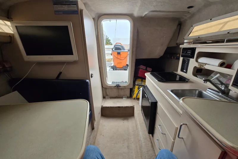 Slide: The Image of Interior of a 1996 Wellcraft 26 Exel SE boat with kitchenette and seating area. - 5