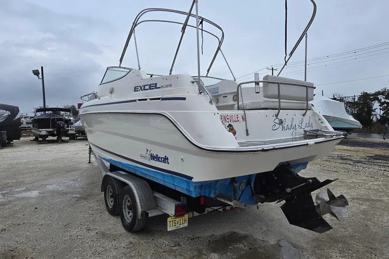 Slide: The Image of 1996 Wellcraft 26 Exel SE boat on trailer, rear view, in outdoor storage area. - 9