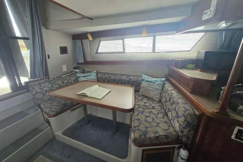 Slide: The Image of Interior of 1987 Carver 32 Mariner with cozy seating and table. - 12