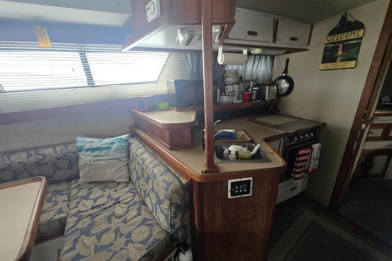 Slide: The Image of Interior of a 1987 Carver 32 Mariner boat with cozy seating and kitchen area. - 13