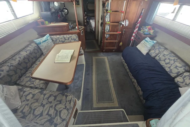 Slide: The Image of Interior of 1987 Carver 32 Mariner boat with cozy seating and table. - 15
