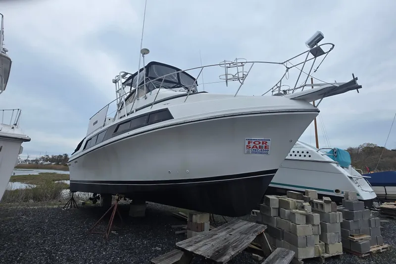 Slide: The Image of 1987 Carver 32 Mariner boat for sale, elevated on blocks, with "For Sale" sign. - 20