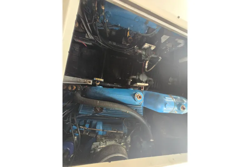 Slide: The Image of Engine compartment of a 1987 Carver 32 Mariner boat, showcasing blue engine components. - 21