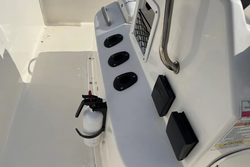 Slide: The Image of 2019 Bayliner Element F18 boat interior with rod holders and fire extinguisher. - 27