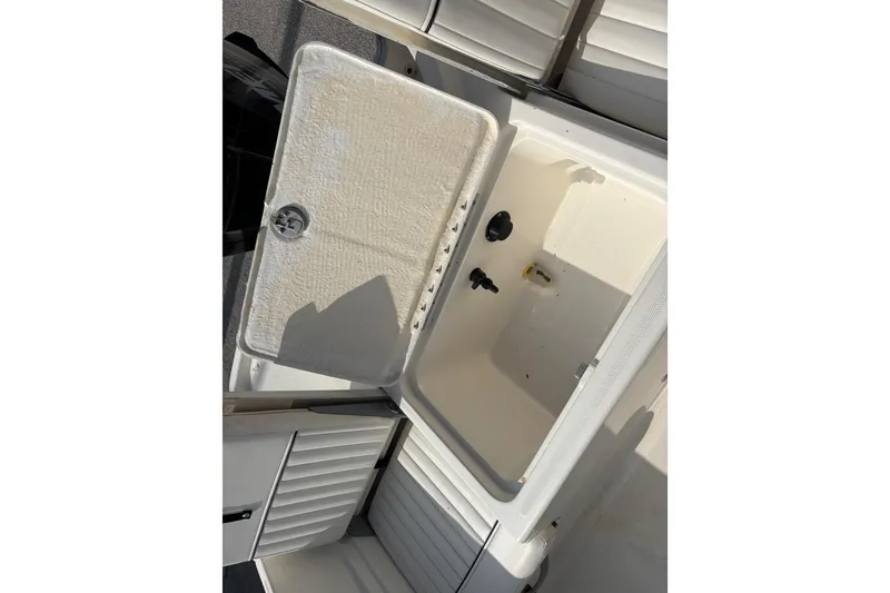 Slide: The Image of 2019 Bayliner Element F18 boat storage compartment with open lid, showcasing interior space. - 34