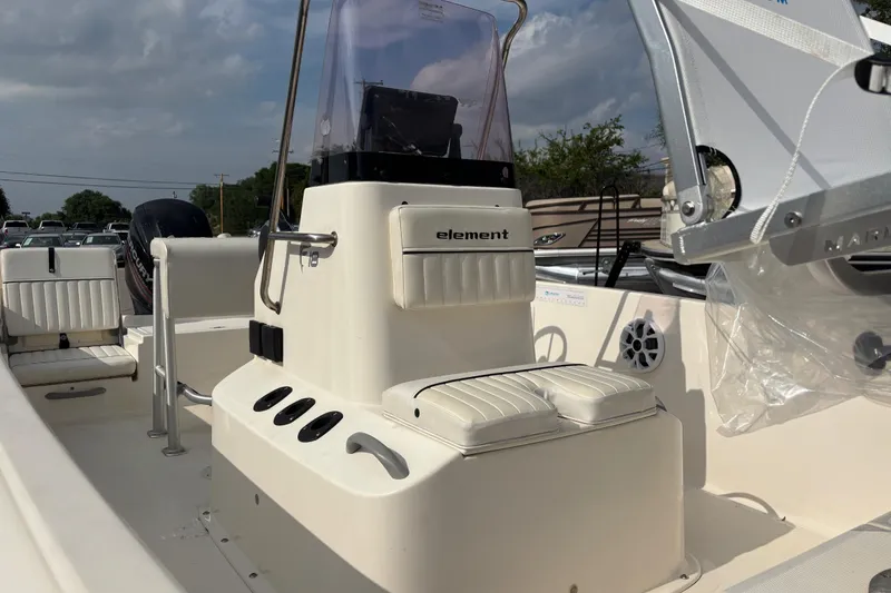 Slide: The Image of 2019 Bayliner Element F18 boat interior with seating and console under a cloudy sky. - 40
