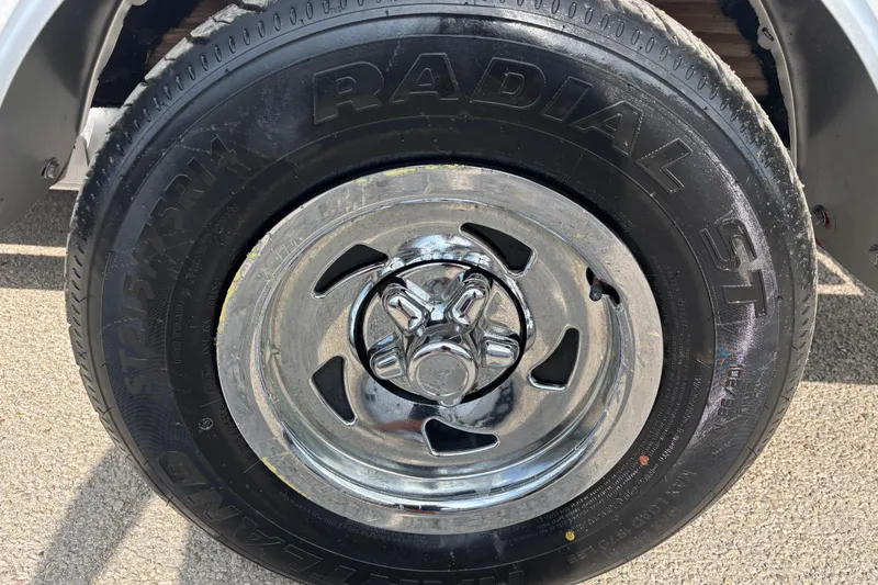 Slide: The Image of Chrome wheel and radial tire on a 2019 Bayliner Element F18 boat trailer. - 56