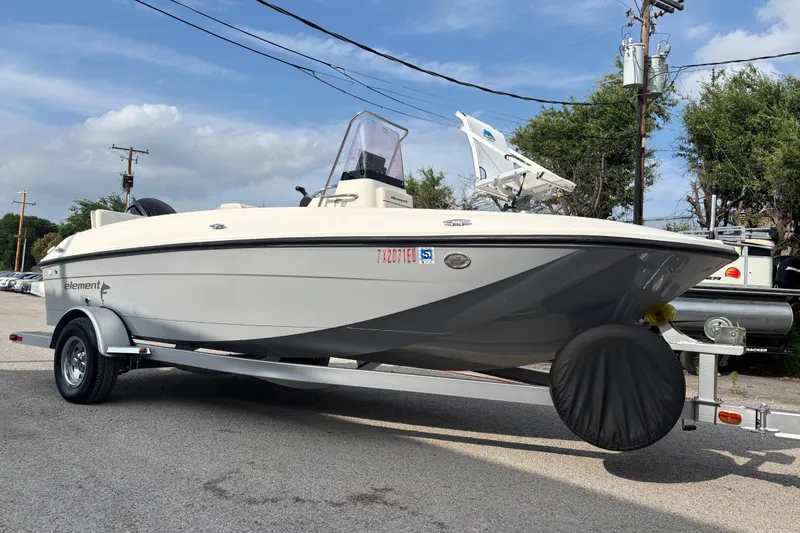 Slide: The Image of 2019 Bayliner Element F18 boat on trailer, parked outdoors under a clear sky. - 57