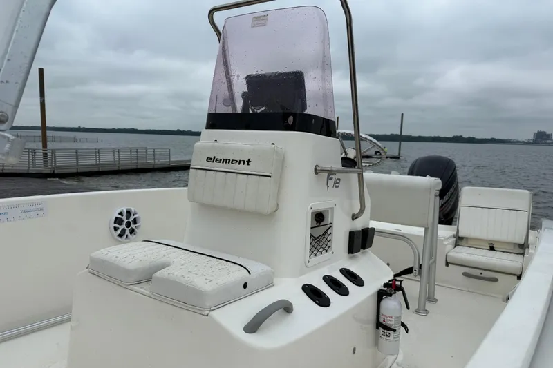 Slide: The Image of 2019 Bayliner Element F18 boat with console, docked by a lake under cloudy skies. - 74