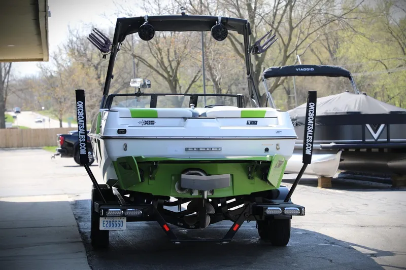 Slide: The Image of 2019 Axis T22 boat on trailer, green and white design, parked outdoors. - 12