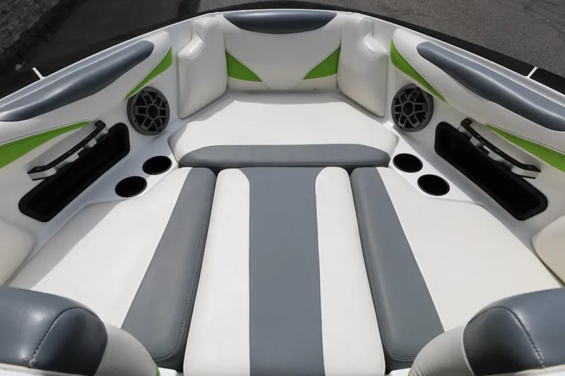 Slide: The Image of 2019 Axis T22 boat interior with gray and white seating, green accents, and cup holders. - 3