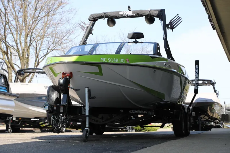 Slide: The Image of 2019 Axis T22 boat on trailer, green accents, parked outdoors. - 4