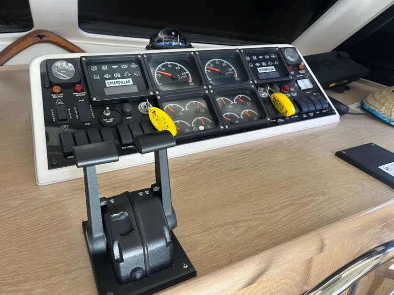 Slide: The Image of Das Bild zeigt das Steuerpult einer Riviera 43 Open Flybridge von 1997 mit verschiedenen Instrumenten und Hebeln. - 25