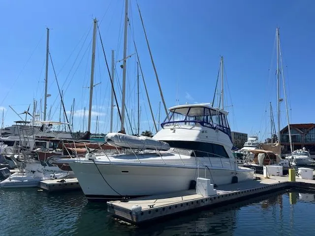 Slide: The Image of 1997 Riviera 43 Open Flybridge yacht docked at marina on a sunny day. - 17