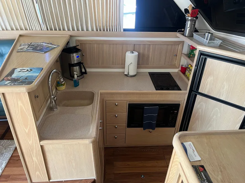 Slide: The Image of Die Küche einer Riviera 43 Open Flybridge von 1997 mit Spüle, Herd und Mikrowelle. - 34